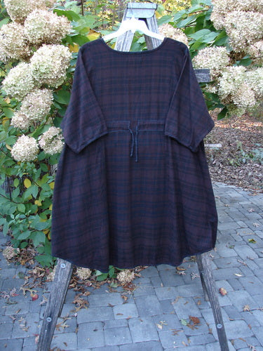 Barclay Flannel Keyhole Drawcord Pocket Dress Brum Plaid Size 2 displayed on a wooden easel. Knee-length, ¾ sleeves, keyhole neckline, drawstring waist, wide sleeves, high side pockets.