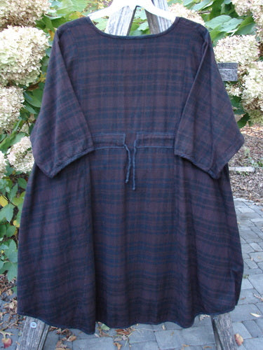 Barclay Flannel Keyhole Drawcord Pocket Dress in Brum Plaid, size 2, displayed on a wooden chair outdoors, featuring a round neckline, elbow-length sleeves, and a tie waist, embodying Bluefishfinder's vintage style.