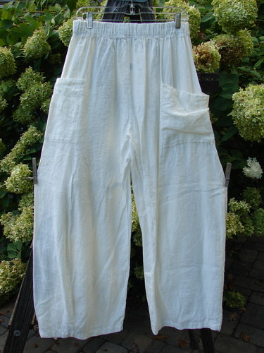 Image alt text: Barclay Linen Side Pocket Pepper Pant, a pair of white pants with a billowy shape and cropped length, featuring two front wrap pockets. Made from medium weight linen, size 1.