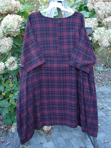 Barclay Flannel Bottom Bell Pocket Dress Merlo Plaid Size 2 hangs outdoors, showcasing its loose fit, rounded neckline, wide sleeves, and dual high side pockets, embodying BlueFishFinder's vintage style.