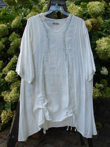 Barclay Linen Venetian Tunic Dress: A white dress with a feminine shape, curved seams, and a softly dipped V neckline. Made from mid-weight linen, it features double front draw cords, high side vents, and a beautiful drape. Size 1.