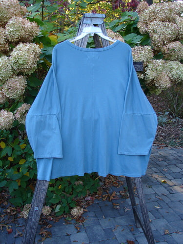 Barclay NWT Two Pocket Mariposa Pullover Butterfly Sea OSFA displayed on a hanger, showcasing its rounded neckline, dolman shoulders, wide sleeves, and dual drop front pockets, embodying BlueFishFinder's unique vintage style.