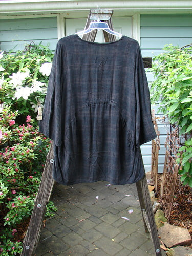 Barclay Linen Rayon High Low Tunic in Unpainted Black Plaid, Size 2, displayed on a wooden rack. The tunic features three-quarter sleeves, reflecting BlueFishFinder's vintage, creative clothing style.