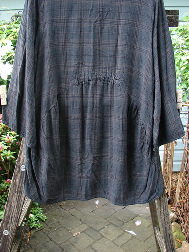 Barclay Linen Rayon High Low Tunic Unpainted Black Plaid Size 2 on a clothes rack, showcasing three-quarter sleeves and a distinctive high-low hem.