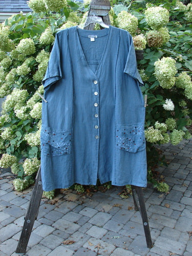 A Barclay Linen Double Tie Back Jacket in Rain Shower Dusty Blue Teal, size 2. A medium weight linen jacket with a deep V-shaped neckline, A-line sweep, and front drop flop pockets. Features exterior vertical stitchery and a varying hemline.