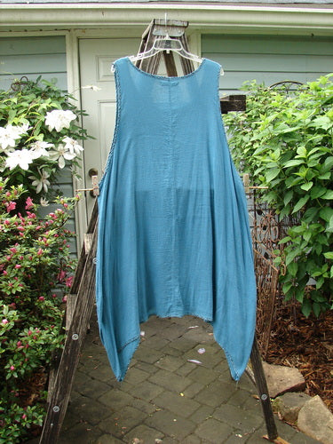 Barclay Crinkle Gauze Contrast Ditsy Daisy Pinafore Unpainted Teal Size 2 displayed on a clothes rack.