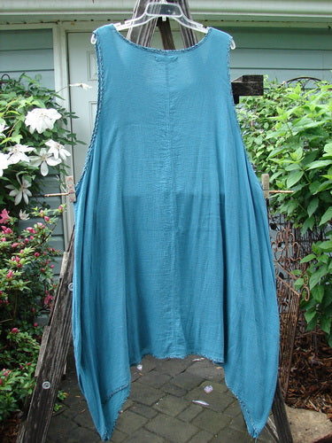 Barclay Crinkle Gauze Contrast Ditsy Daisy Pinafore Unpainted Teal Size 2 displayed on a clothes rack, highlighting its textured fabric and delicate pattern.