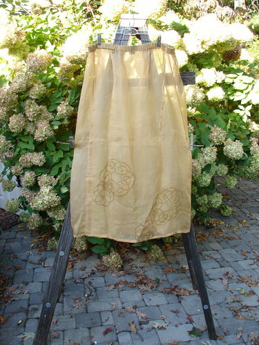 2000 Silk Organza Skirt Wind Turn Bone Size 2: A skirt on a wooden stand, featuring a floating lined flare and vertical exterior sectional panels.