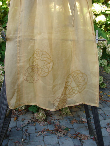 2000 Silk Organza Skirt with Celtic Wind Turn Pattern, Bone color. A yellow cloth with a pattern on it, close-up of fabric.
