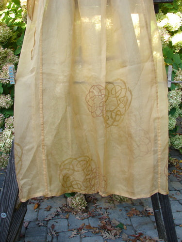 2000 Silk Organza Skirt Wind Turn Bone Size 2: A yellow skirt with a pattern on it, featuring a lined flare, elastic waistline, and vertical exterior panels.