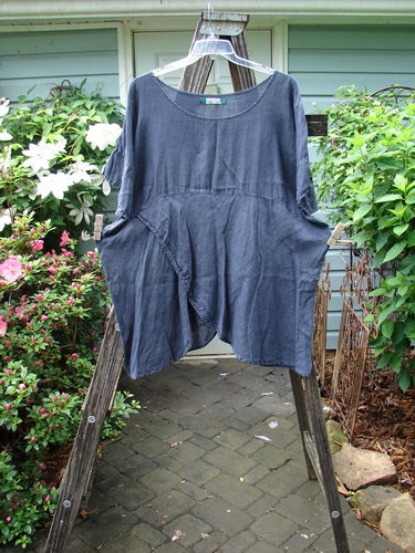 Barclay Linen Lower Wrap Tunic Top Unpainted Steel Navy Size 2 displayed on a rustic wooden ladder, highlighting its three-quarter sleeves and unique sectional lower wrap design.