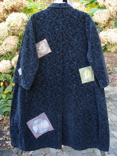 1998 Patched Tapestry Coat Bountiful Sun Guy Black OSFA hanging outside; features swirling velvet fabric with sun, abstract, emblem, and Celtic cross patches, capturing BlueFishFinder's vintage, expressive style.