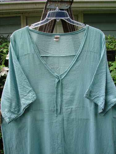 Barclay Batiste Deep Neck Tie Dress in Unpainted Spearmint, Size 2, displayed on a hanger. Short-sleeved with a deep neckline, highlighting its unique vintage style from Bluefishfinder.com.