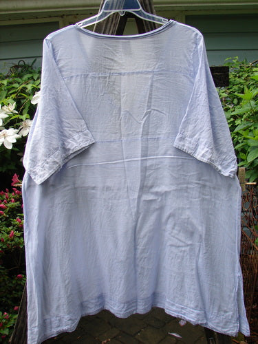 Barclay Batiste Deep Neck Tie Dress in Unpainted Lilac, Size 2, displayed on a clothes hanger, showcasing its short sleeves and slight blemish on the lower single sleeve.