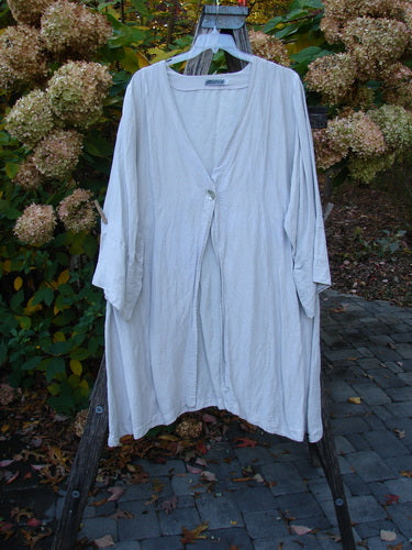 Barclay Hemp Silk Single Button Cardigan Unpainted Dew Size 2, featuring a deep V neckline, wide banded sleeves, single shell button, and curved seams, elegantly draped on an outdoor wooden ladder.
