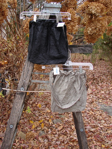 2000 NWT Shaunting Silk Bags Unpainted Black and Cement OSFA hang from a weathered ladder outdoors, showcasing their crinkled silk texture and elastic-topped closure, embodying Bluefishfinder.com's vintage, expressive style.