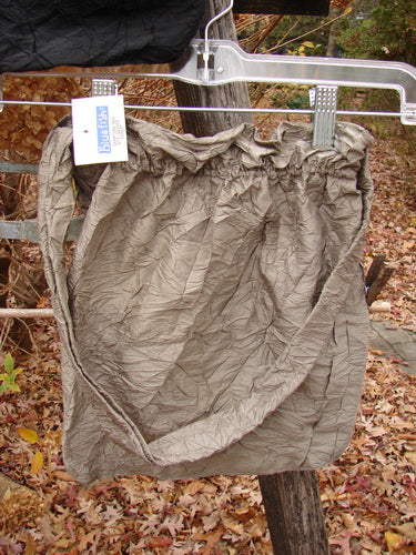 2000 NWT Shaunting Silk Bags Unpainted Black and Cement OSFA, elegantly displayed outdoors, feature crinkled silk texture with a sweet bubble top ruffle, perfect for enhancing any ensemble.