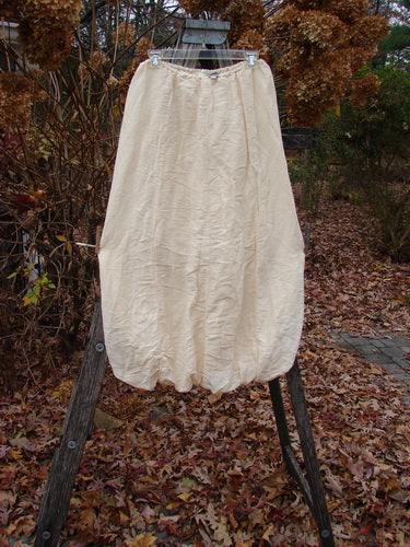 2000 Hemp Silk Reverse Skirt Unpainted Parchment Size 1 displayed on a clip hanger, showcasing its voluminous design and elastic bubble hem, reflecting vintage Blue Fish Clothing's creative and individualistic ethos.