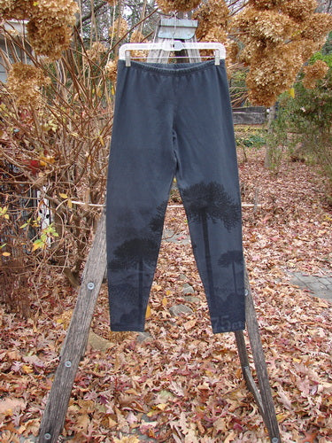 Barclay Cotton Lycra Straight Pant Shadow Tree Lux Silhouette Size 1 displayed outdoors on a wooden ladder, showcasing tree silhouette detailing near the lower legs, complemented by a forgiving fit with a full elastic waistband.