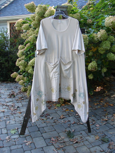 Image alt text: Barclay Cotton Lycra Double Pocket Bounce Tunic Dress, featuring a white shirt with oversized front pockets, curvy seams, and a varying hemline.