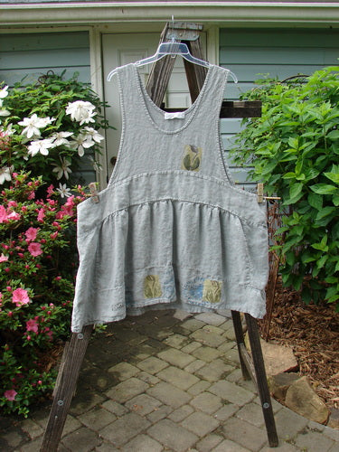 A vintage 1998 Botanicals Leafhopper Jumper apron from BlueFishFinder, showcasing a single tulip motif in heavy linen. Unique design with double-paneled waist, bib style neckline, and dropped sides. One size fits all.