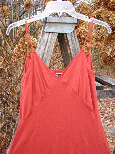 The 2000 Wool Pointelle Lulu Slip Dress Sienna Smaller Size 0 features a spaghetti-strap design with eyelets and criss-cross bodice, draped elegantly on a wooden trellis.