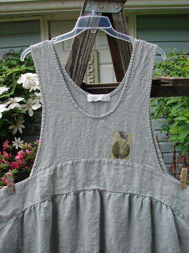 A vintage 1998 Botanicals Leafhopper Jumper apron from Birdsong in Perfect Condition Heavy Weight Linen. Features a double-paneled waist, bib-style front and back neckline, and a single tulip theme paint. One size fits all.