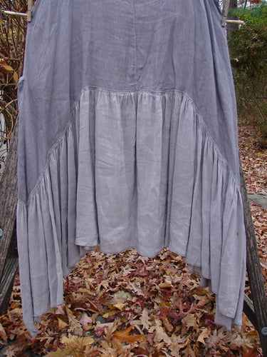 Barclay Gauze Silk Summer Frock Jumper Unpainted Grey Haze Size 1, featuring a loose fit with a cotton gauze upper and silk lower flounce, displayed outdoors with a ruffled hemline and exterior wrap pockets.