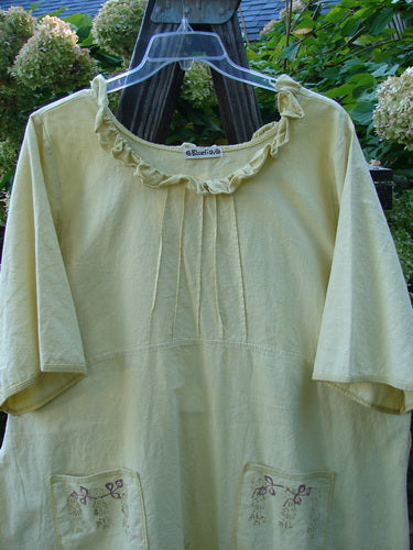 Image alt text: Barclay Linen Duet Sunrise Dress, a yellow shirt on a swinger with a pocket, part of the Blue Fish Clothing Summer Collection in Sunshine. Sweet baby doll tunic with a curly cotton neckline, pleated upper bodice, varying hemline, widening shape, and front pockets. Made from a cotton linen fabric similar to light denim. Size 2.