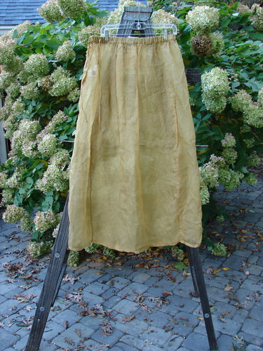 2000 NWT Silk Organza Skirt Unpainted Bone Size 2: A skirt on a mannequin, close-up of a skirt, yellow skirt on a stand, yellow cloth on a wooden stand, close-up of a plant, close-up of a flower.