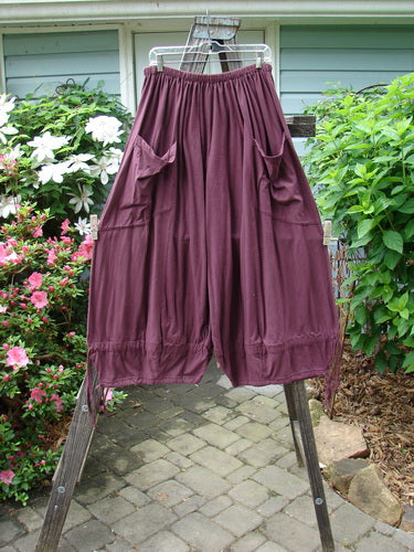 Barclay Tie Bottom Square Pant Unpainted Maroon Size 2 on a clothes rack, showcasing its full elastic waistline, oversized pockets, and wide lower legs with tie bottoms.