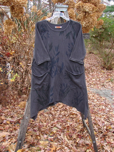 Barclay Sunny Day Pocket Tunic Dress Flutter Bamboo Steel Meteorite Size 1 draped on a wooden ladder, featuring a scoop neckline, mid-length sleeves, asymmetrical hem, and two large rounded pockets.
