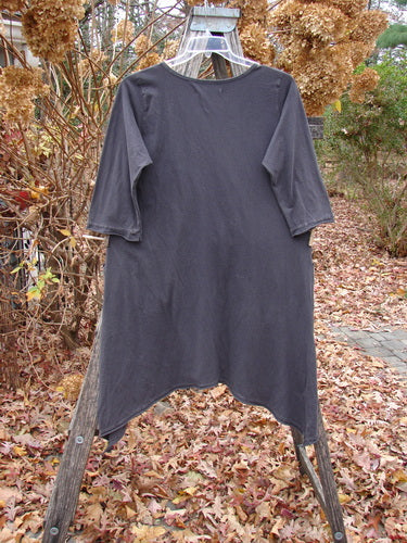 Barclay Sunny Day Pocket Tunic Dress Flutter Bamboo Steel Meteorite Size 1, featuring a rounded neckline, three-quarter sleeves, and flutter edges, displayed on a wooden ladder with autumn leaves and hydrangeas.