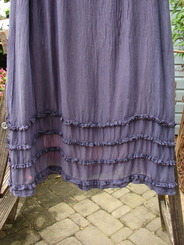 Barclay NWT Pas de Deux Quad Contrast Ruffle Skirt on wooden porch. Purple ruffle dress with elastic waist, drawcord, lower ruffle accents, and sheer lining. Layers of continuous ruffles create a unique silhouette.