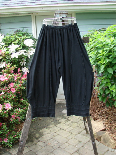 A pair of Barclay Reverse Stitch Contrast Cuff Pant Unpainted Black Size 2, featuring a full elastic waistline and wide, tapered, ribbed cuffs, displayed on a rack.