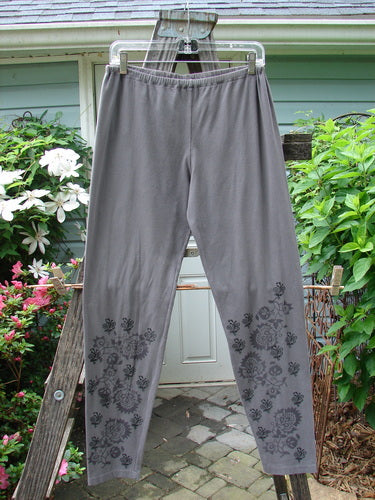 A pair of Barclay Cotton Lycra Legging Botanicals Grey Plum Size 2 hanging on a clothesline.