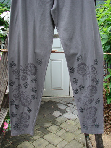 Barclay Cotton Lycra Legging Botanicals Grey Plum Size 2, featuring a relaxed fit with floral designs, displayed on a rack.
