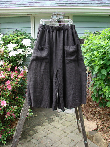 Barclay Linen Crop Wide Leg Pocket Pant Unpainted Black Size 2 displayed on a rack, showcasing oversized upper pockets, a thicker elastic waist, and wide lower legs in lightweight linen.