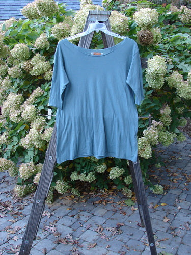 Image alt text: Barclay Batiste Raw Edge Tee Top on wooden rack, featuring three-quarter length sleeves, soft neckline, and roll over edgings. Size 1.