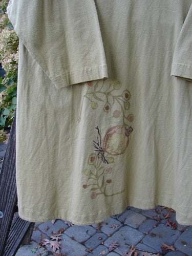 1998 Botanicals Bell Flower Top Root Berry Seed Size 2: A long sleeved white shirt with a flower design, featuring a belled A-line shape, softly rounded neckline, and blue fish signature patch.