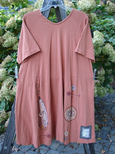 1998 4 Elements Tress Dress Starburst Arausio Size 2: A pink dress on a clothesline with a sweet A-line shape and front pockets.