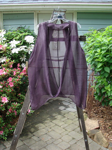 Barclay Silk Infinity Twist Pullover Unpainted Rich Plum Size 2 displayed on a wooden rack, showcasing its unique open front with a lower twist and elegant curvy vertical seams.