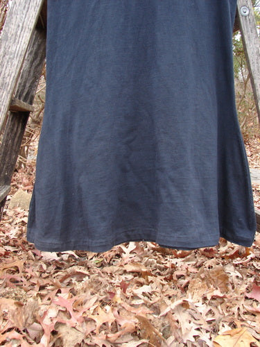 1992 Pedestal Dress Unpainted Black Size 1 displayed outdoors, showcasing its empire waist and fishtail side flutters, hinting at BlueFishFinder’s vintage aesthetic.