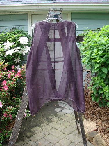 Barclay Silk Infinity Twist Pullover Unpainted Rich Plum Size 2 displayed on a wooden ladder, showcasing its unique open front, lower twist, and varying hemline.