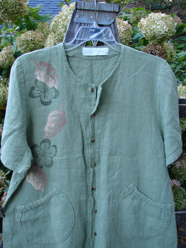 1998 Botanicals Robin's Top: A green shirt with flowers, featuring a smaller back shoulder line, elastic-topped pockets, and perfect buttons. Made from heavy-weight linen. Size 1.