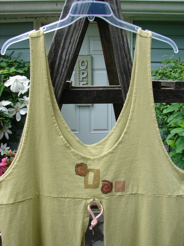 Vintage 1996 4 Corner Pocket Apron in Geo Key Lemon design on a clothes hanger outdoors. Features include double-layered bodice, oversized front tie-on pockets, waist vents, and unique U-shaped neckline. From BlueFishFinder.