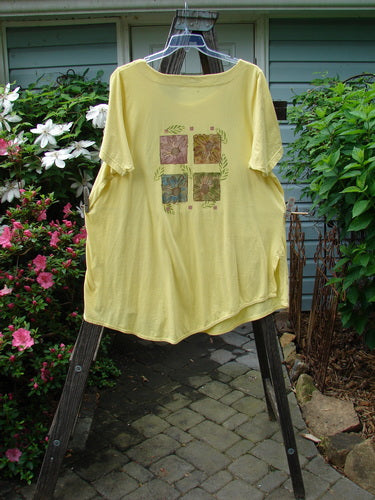 Barclay Double Pocket Lace Twinkle Top Daisy Power Sunshine Size 2 displayed on a hanger, showcasing its A-line shape, lace-topped pockets, and daisy-themed patchwork design.