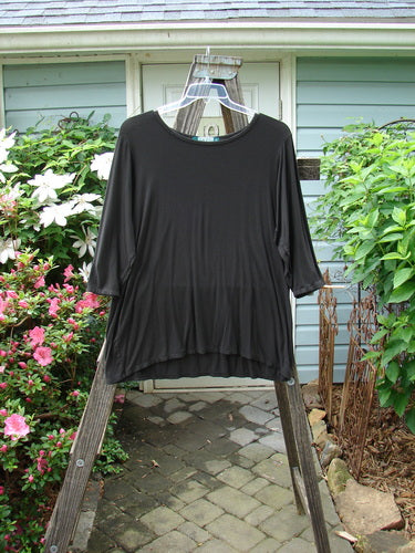 Barclay Rayon Lycra Basic Top Unpainted Charcoal Size 2 displayed on a hanger with three-quarter length sleeves and a unique upward scoop front hemline.