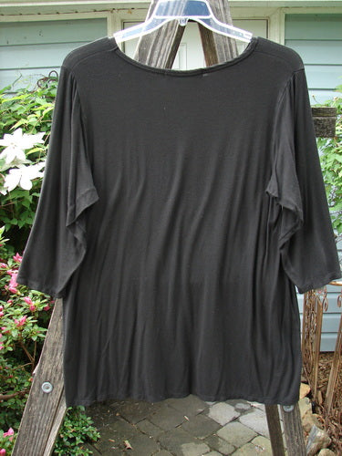 Black Barclay Rayon Lycra Basic Top Unpainted Charcoal Size 2 displayed on a wooden pole, showcasing three-quarter sleeves, upward scoop front hemline, and straight back hem.