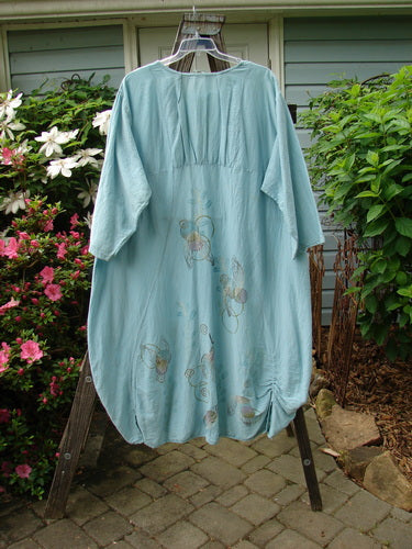 Barclay Hemp Cotton Silk Voile Belle Dress Wing Water Size 2, featuring a dramatic rear reverse yoke backline, upper pleats, dual vertical ruching, and a widening then tapering bell shape, displayed on a clothes rack.